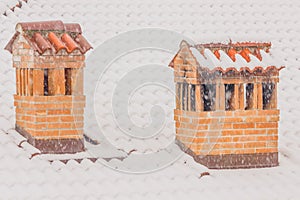 The chimneys of a house during a heavy snowfall