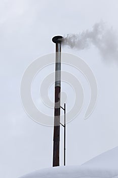 chimneys on the roof of a building in winter