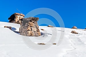 chimneys on the roof of snowy hut