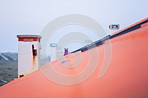 Chimneys in a Row on Red Clay Tiles Rooftop