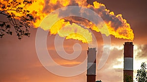 chimneys of a thermal power plant against the background of a red sunset. color nature