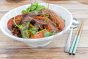 China, Chongqing Sichuan spicy dried chilli small lobsters, among other dishes in the background. Food photography at Chinese