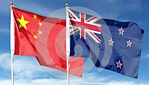 China flag and New Zealand flag on cloudy sky.