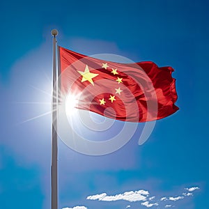 China flag, unfurled in all its glory on a sunny day against the clear blue sky.