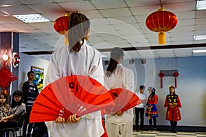 Girls dancing with red fans in celebration of the Chinese New Year