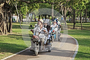 China, Hainan Island, Sanya bay - City street, Chinese electric moped tricycle, elderly chinese couple on a