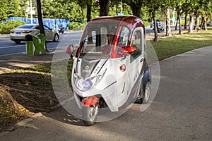 China, Hainan Island, Sanya bay -: City street, Chinese tricycle electric moped, Chinese woman on an electric