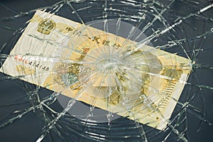 China money, Fall of Chinese currency, Weakening Yuan 1 Yuan banknote lying behind broken glass, Financial concept or insurance