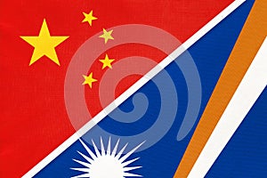 China or PRC vs Marshall Islands national flag from textile. Relationship between Asian and Oceania countries