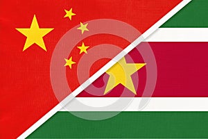 China or PRC vs Suriname national flag from textile. Relationship between asian and american countries