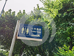 China public toilet sign under the tree with beautiful sunbeam