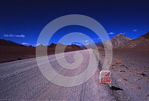 China-Tibet-December 2002 road in the dirt mountains with blue s