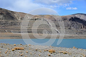 China, Tibet.Nature-created image of Buddha`s eyes on the mountain on the shore of holy lake Chovo Co 4765 m in summer day