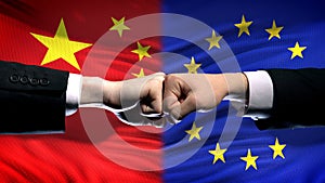 China vs EU conflict, international relations crisis, fists on flag background