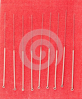 Chinese acupuncture needle on red