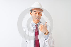 Chinese architect man wearing coat and helmet standing over isolated white background doing happy thumbs up gesture with hand