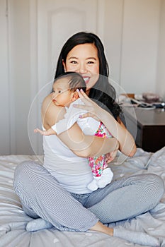 Chinese Asian mother holding cute adorable newborn infant baby