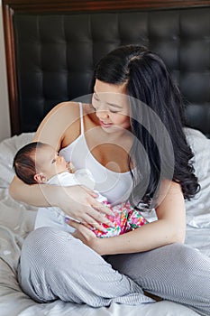 Chinese Asian mother holding cute adorable newborn infant baby son daughter