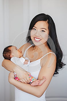 Chinese Asian mother holding cute adorable newborn infant baby son daughter