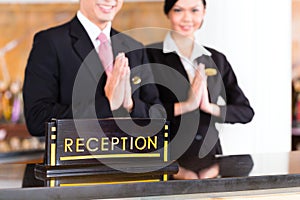 Chinese Asian reception team at hotel front desk