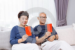 Chinese Asian senior elders giving red envelope or Hong bao to younger generation during Chinese new year. photo