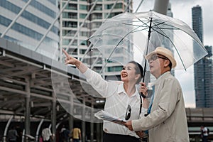 Chinese asian senior tourist couple having sightseeing tour in city