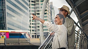 Chinese asian senior tourist couple having sightseeing tour in city