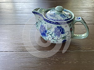 chinese blue flower-style teapot on antique dark brown table