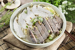 Chinese bowl of wanton noodle with beef anf pork on the table in