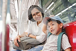 Chinese boy and mother enjoy travelling by commuter train