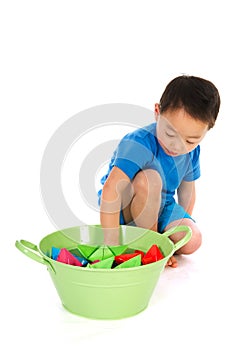 Chinese boy playing with paper boats