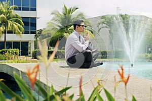 Chinese Business Man Meditate Yoga Outside Office Building