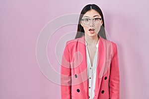Chinese business young woman wearing glasses afraid and shocked with surprise expression, fear and excited face