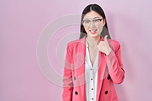 Chinese business young woman wearing glasses doing happy thumbs up gesture with hand