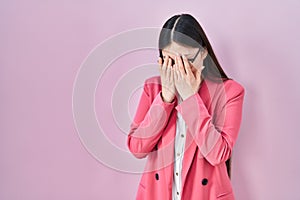 Chinese business young woman wearing glasses with sad expression covering face with hands while crying