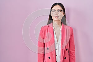 Chinese business young woman wearing glasses smiling looking to the side and staring away thinking