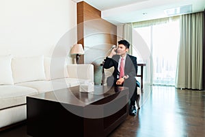 Chinese Businessman on business trip in hotel suite