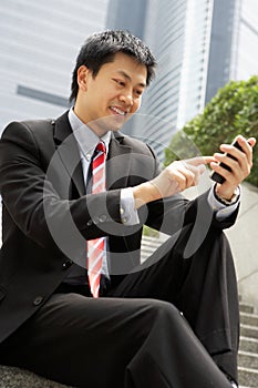 Chinese Businessman Dialling On Mobile Phone