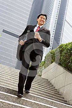 Chinese Businessman Rushing Down Steps photo