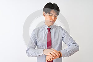 Chinese businessman wearing elegant tie standing over isolated white background Checking the time on wrist watch, relaxed and