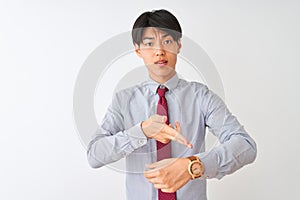 Chinese businessman wearing elegant tie standing over isolated white background In hurry pointing to watch time, impatience, upset