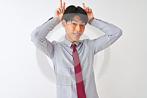 Chinese businessman wearing elegant tie standing over isolated white background Posing funny and crazy with fingers on head as