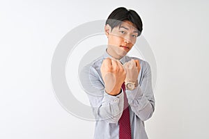 Chinese businessman wearing elegant tie standing over isolated white background Ready to fight with fist defense gesture, angry