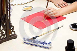 chinese calligraphy Master writing new year golden character Fu means Blessing, Good Fortune, Luck