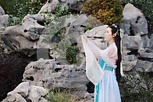 Chinese classic beauty in traditional ancient drama costume stand by rockery