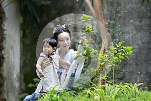 Chinese classic woman in Hanfu dress enjoy free time with baby and close friends