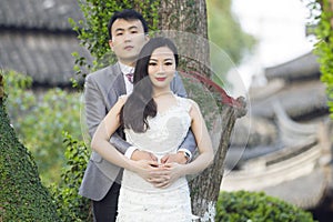 Chinese couple wedding portraint in front of Old trees and old building