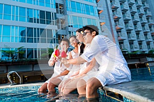 Chinese couples drinking cocktails in hotel pool bar