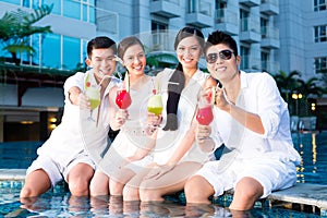 Chinese couples drinking cocktails in hotel pool bar