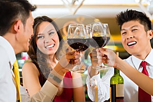 Chinese couples toasting with wine in restaurant